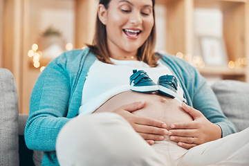 Image showing Mother, pregnancy and pregnant stomach in hands, woman with shoes for baby, excited about childbirth and happy at family home. Happiness, mama and love, prenatal health and wellness with maternity.