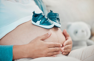 Image showing Mother with pregnant stomach in hands, shoes for baby with pregnancy, relax and waiting for birth with love and hope for healthy child. Woman, prenatal care and mom at family home, ready for newborn.