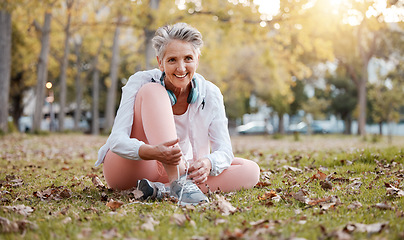 Image showing Fitness, shoes and old woman in park for workout, cardio training or morning running. Happy senior female, fitness and tie sneakers on grass lawn to start exercise, healthy lifestyle or body wellness