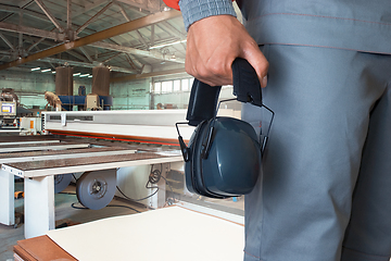 Image showing Worker wearing protective headphones at factory