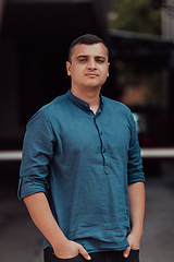 Image showing A portrait of a modern man, exuding confidence and style, against an outdoor backdrop, showcasing his charisma and fashionable demeanor.