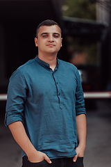 Image showing A portrait of a modern man, exuding confidence and style, against an outdoor backdrop, showcasing his charisma and fashionable demeanor.