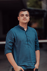 Image showing A portrait of a modern man, exuding confidence and style, against an outdoor backdrop, showcasing his charisma and fashionable demeanor.