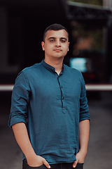 Image showing A portrait of a modern man, exuding confidence and style, against an outdoor backdrop, showcasing his charisma and fashionable demeanor.