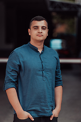 Image showing A portrait of a modern man, exuding confidence and style, against an outdoor backdrop, showcasing his charisma and fashionable demeanor.