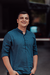 Image showing A portrait of a modern man, exuding confidence and style, against an outdoor backdrop, showcasing his charisma and fashionable demeanor.