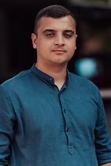 Image showing A portrait of a modern man, exuding confidence and style, against an outdoor backdrop, showcasing his charisma and fashionable demeanor.