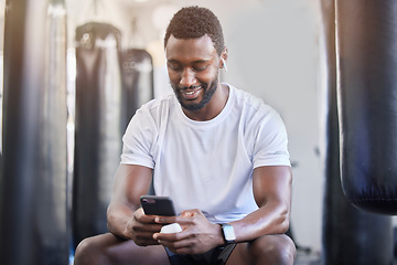 Image showing Fitness, music and phone with black man in gym for training, workout and exercise. Social media, streaming and internet with bodybuilder relax with mobile in sports center for health and performance