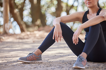 Image showing Nature, hiking and woman stop for breath or sitting on ground in forest to relax on outdoor run or workout. Health, fitness and wellness, a tired girl on hike on break from running exercise on path.