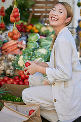 Image showing Asian woman, supermarket and grocery shopping and tomato, customer and retail, vegetable fresh product and buying food at store. Young happy female and smile, sale and discount on groceries at market