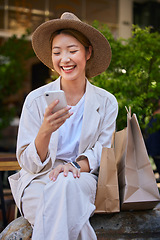 Image showing Shopping, city and woman in Japan with smartphone for ecommerce website, fintech and internet deal on sales, product promotion and discount. Cellphone, asian or Japanese girl and shopping bag at mall