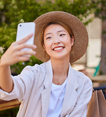 Image showing Selfie, smartphone and shopping bag of woman in city or park for social media post, profile picture update and fashion blog in Japan. Cellphone photography, happy woman or influencer with retail tips
