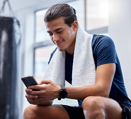 Image showing Fitness, phone and man relax in gym tracking workout, exercise or progress on app. Tech, sports and happy male with towel and mobile smartphone for internet browsing, text messaging or social media.