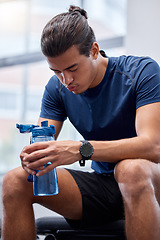 Image showing Fitness, tired or man at gym drinking water, breathing or relaxing on a exercise, workout or cardio training break. Fatigue, wellness or healthy sports athlete resting on bench with bottle of liquid