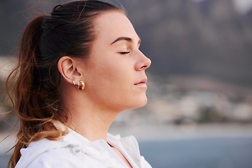 Image showing Woman, face and meditation outdoor, calm and spiritual freedom at beach, prayer and breathe in nature. Young female, prayer and eye closed at ocean, balance mindset and zen faith on holiday vacation