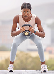 Image showing Fitness, squat and black woman with weight in the city, exercise energy and training for health on a rooftop in Turkey. Wellness, strength training and portrait of a girl with a kettlebell for muscle