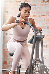 Image showing Gym, fitness or black woman on a bike machine in training, cardiovascular exercise or full body workout. Bicycle, energy or African girl athlete cycling for a healthy heart, sports or speed challenge