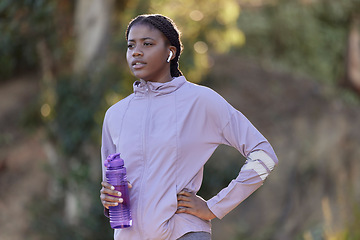 Image showing Exercise, water bottle and black woman outdoor, fitness and workout for wellness, power or health. Nigerian girl, young female or athlete with liquid, hydration or training in nature, rest or earbuds
