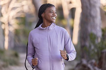 Image showing Fitness, running and black woman smile on a sport run in forest park outdoor with happiness. Happy, African and exercise runner feeling freedom from cardio, marathon training and motivation in nature