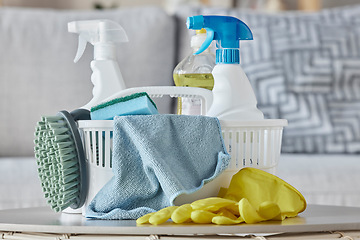 Image showing Cleaning products, brush and basket on table in home living room for housekeeping. Hygiene, spring cleaning and cleaning supplies, gloves and chemicals for disinfection, germs or bacteria prevention.