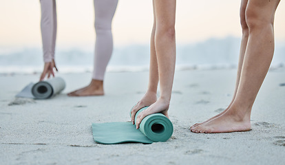 Image showing Fitness, beach and women roll yoga mat getting ready for workout, exercise or stretching. Zen, meditation or hands of females, girls or friends outdoors on beach sand rolling mat for pilates training