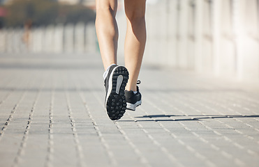 Image showing Runner, feet and woman on path to run for fitness, training and outdoor city workout. Exercise, health and wellness, close up sports shoes, girl running with motivation for growth at race or marathon