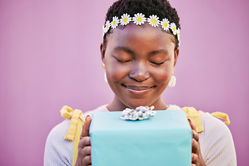 Image showing African woman, box and gift with eyes closed in studio, wall and surprise for birthday, celebration or smile. Black woman, present or happiness for spring flower crown, beauty and lavender background