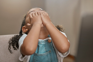 Image showing Child, hands on face and covering eyes for hide and seek game at home while playing for fun, entertainment and fun activity. Cute girl kid on house chair while hiding, playful and doing peekaboo