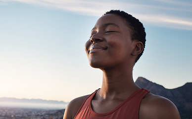 Image showing Fitness, calm and breathing of black woman outdoor in nature, mountains and blue sky background for yoga wellness, meditation and zen energy. Face of girl breathing for peace, freedom and mindfulness