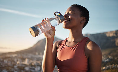Image showing Black woman, runner and drinking water for outdoor exercise, training workout or marathon running recovery. African woman, healthy athlete and hydrate with bottle for fitness, health and cardio run