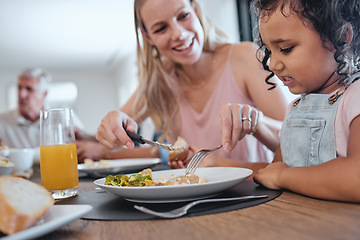 Image showing Family, mother and cutting food for girl while having lunch at dinner table in home. Love, foster care and happy mom helping child with eating, smiling and enjoying a delicious meal together in house