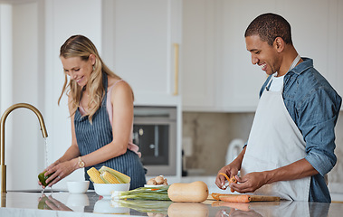 Image showing Cooking, food and love with a couple in the kitchen preparing a meal together for lunch or supper in their home. Health, diet and nutrition with a diversity man and woman bonding while making dinner