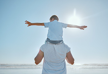 Image showing Family, beach and summer vacation for freedom with a child on shoulder of father with hands outstretched for happiness against blue sky. Man and kid son together at sea for trust, nature and peace