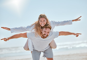 Image showing Playful, travel and couple with freedom at the beach for summer love, quality time and holiday in Costa Rica. Nature, flying piggyback and portrait of man and woman at the ocean for marriage vacation