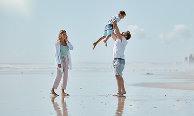 Image showing Family, beach and father lifting kid on vacation, holiday or summer trip outdoors. Love, support and care of mother, man and boy playing, bonding and having fun while enjoying quality time together