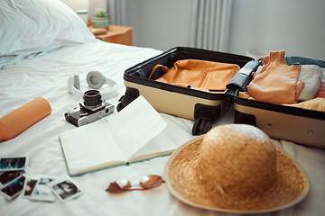 Image showing Travel, luggage and bedroom with a suitcase, hat and camera on a bed in a hotel during holiday or vacation. Hospitality, tourist and resort with luggage in a room for traveling or sightseeing abroad