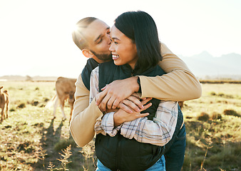 Image showing Cow farm, love and couple kiss in the countryside relax on a sustainability farm with cows. Interracial happy couple, summer and marriage smile of people with a hug in nature on a grass field