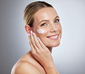 Image showing Woman, skincare and cream for face on studio background with sunscreen, makeup product or luxury beauty cosmetics. Portrait of happy model, facial lotion and natural dermatology, aesthetic and health