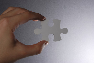 Image showing Hand holding a puzzle piece