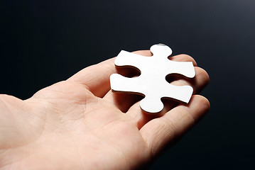 Image showing Hand holding a puzzle piece