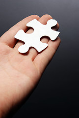 Image showing Hand holding a puzzle piece