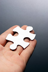 Image showing Hand holding a puzzle piece