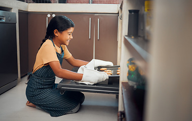 Image showing Child, nutrition and cookies tray in oven kitchen for baking, child development and learning cooking skills and happy in family home. Hungry little girl, smile and bake recipe for eating in house