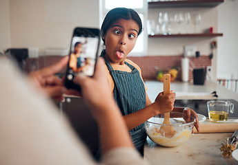 Image showing Funny child, phone and baking in home with mother taking photo for social media or food blog post in their home kitchen while making cake. Girl kid making comic face while cooking with a woman