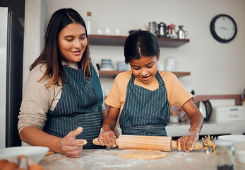 Image showing Family, baking and home kitchen with a mother teaching daughter to bake cookies with rolling pin for dough on counter. Woman and girl child together for cooking food education and development at home