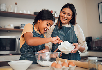 Image showing Baking, family and children with a mother and daughter learning about cooking in the kitchen of their home. Food, kids and help with a girl and woman teaching her child how to bake with eggs or flour