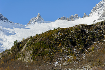 Image showing high snow-capped mountains over rocks