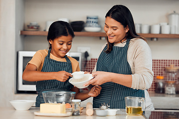 Image showing Learning, family and cooking cake with mother for bonding, wellness and help with smile. Happy family, kitchen and mom teaching young daughter baking skill with flour measurement in home.