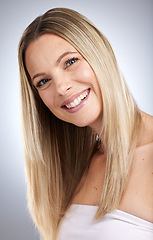 Image showing Portrait, hair and beauty with a model woman in studio on a gray background to promote keratin treatment. Face, haircare and smile with a happy young female inside for natural hair care or growth