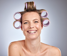 Image showing Hair care, styling and woman with a roller set, beauty maintenance and happy against a grey studio background. Hair dresser, prepare and face portrait of a model curling and grooming her hair